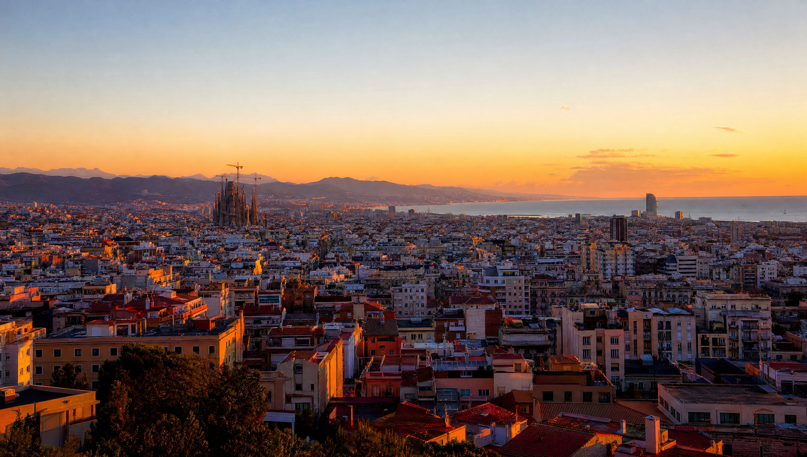 Skyline de Barcelona al atardecer con la Sagrada Familia y la costa mediterranea
